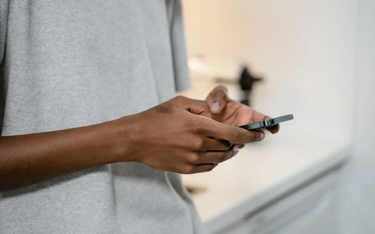 Hands typing a text message on a smartphone